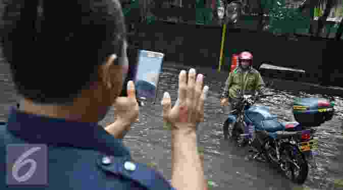 Warga berpose disamping motor saat banjir menggenangi kawasan Sunter, Jakarta, Kamis (25/2). Hujan deras yang mengguyur Jakarta serta sistem drainase yang buruk menjadi penyebab banjir sehingga mengganggu aktivitas warga. (liputan7upcash.com/Immanuel Antonius)