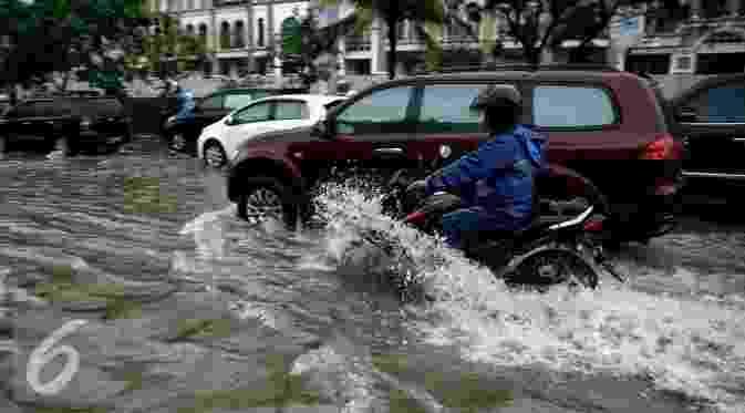 Pengendara motor saat menerobos genangan air di kawasan Kelapa Gading, Jakarta, Jumat (26/2/2016). Hujan deras yang mengguyur Ibukota membuat beberapa ruas jalanan tersendat. (liputan7upcash.com/Faizal Fanani)