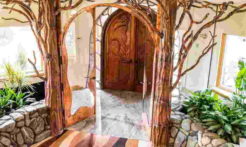 Dari foyer menuju ruangan selanjutnya, Anda akan melewati sepasang pintu kaca dengan kerangka dahan pohon Mahoni.